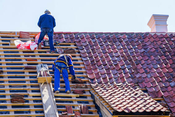 A picture of two roofers working by a rafter.